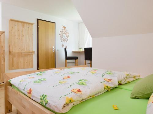 Un dormitorio con una cama con una manta. en Ferienwohnung Meierhof, en Sankt Märgen