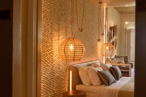 a living room with a couch and two pendant lights at Divelia East in Imerovigli