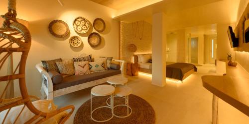 a living room with a couch and some plates on the wall at Divelia East in Imerovigli