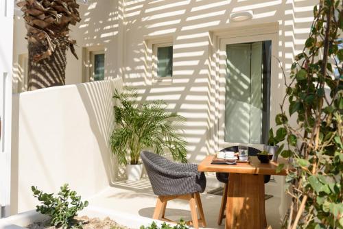 a chair and a table on a patio with plants at Divelia East in Imerovigli