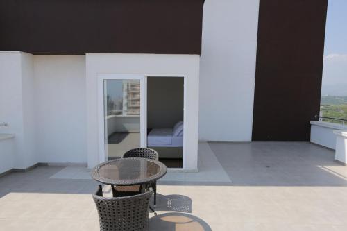 a table and chairs on a balcony with a bed at Upart Home in Mersin