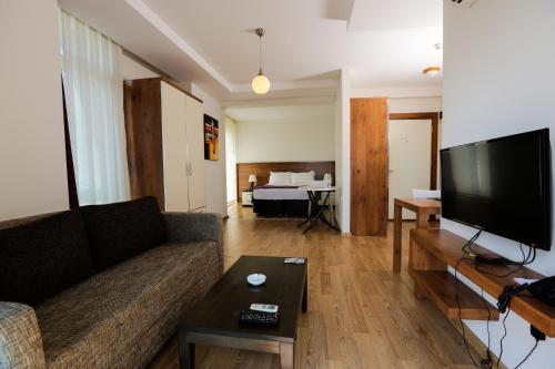 a living room with a couch and a flat screen tv at Upart Home in Mersin