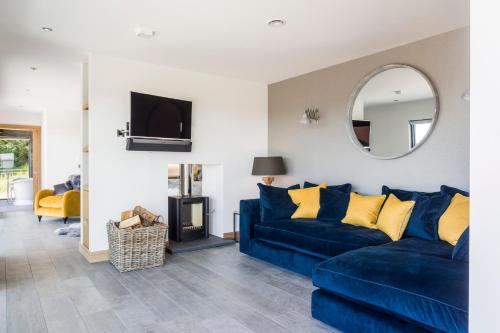 a living room with a blue couch and a mirror at The Hideaway Experience in Dundee