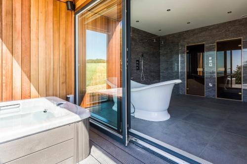 a bathroom with a bath tub and a window at The Hideaway Experience in Dundee