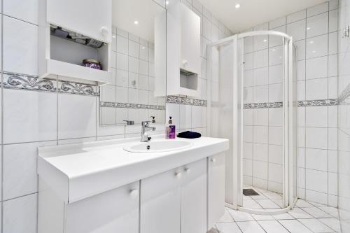 a white bathroom with a sink and a shower at Apartment Bergen Central in Bergen