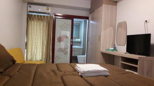 1 dormitorio con 1 cama, TV y espejo en Roseate Bangkok Hotel en Bangkok