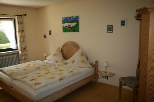 ミッテンヴァルトにあるFerienwohnung Bergtraumのベッドルーム1室(ベッド1台、椅子、窓付)