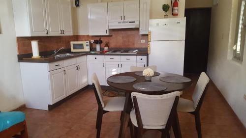 a kitchen with a table and chairs and a white refrigerator at Vista Bella Apartments in Culebra