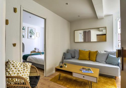 un salon avec un canapé et un lit dans l'établissement Madeleinette, à Strasbourg