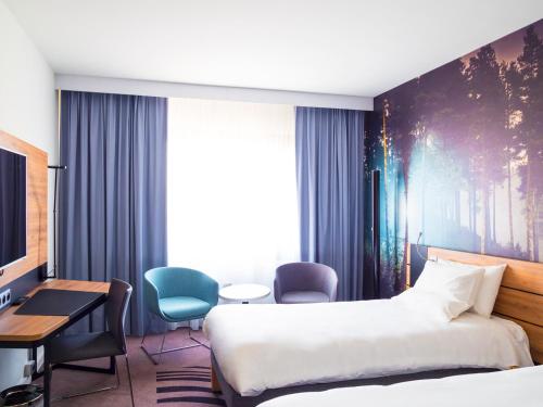 a hotel room with a bed and a desk at Novotel Katowice Centrum in Katowice