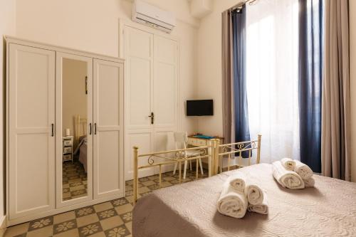 una camera da letto con un letto e asciugamani di Il Tarì Apartment a Palermo