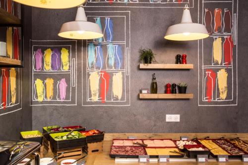 a counter in a restaurant with food on a wall at ibis Vilnius Centre in Vilnius