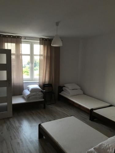 a room with two beds and a window at Noclegi ANNI in Będzin