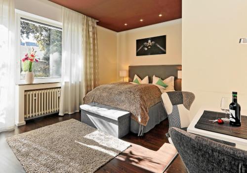 a bedroom with a bed and a window and a table at Design Apartment nähe Düsseldorf in Krefeld