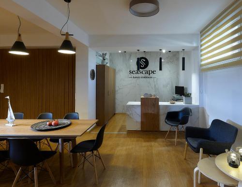 een woonkamer met een tafel en stoelen en een keuken bij Seascape Luxury Residences in Agia Pelagia