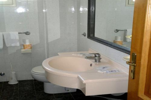 a bathroom with a sink and a toilet and a mirror at Hotel Eden in Sorrento