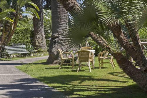 a table and chairs in a park under palm trees at Hotel Eden in Sorrento
