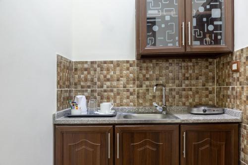 uma cozinha com armários de madeira e um lavatório em 360 Hotel By FHM em Amã