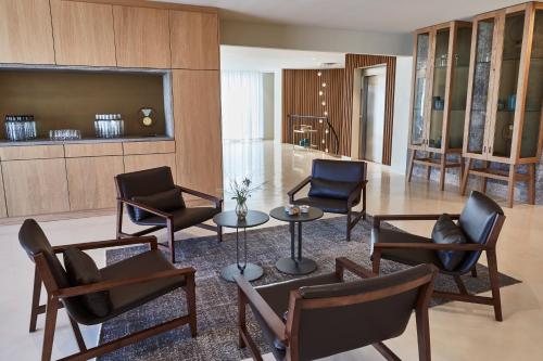 a living room with chairs and a table and a television at 7Pines Resort Ibiza, part of Destination by Hyatt in San Jose