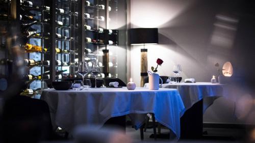 a dining room with two tables with wine glasses at La Mainaz Hôtel Restaurant Genève - Gex - Mijoux in Gex
