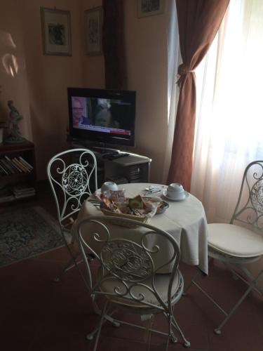 uma sala de estar com uma mesa e cadeiras e uma televisão em La ginestra Chia B&B em Domus de Maria