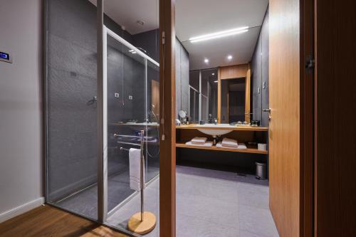 a bathroom with a glass shower and a sink at Hotel Gredič in Dobrovo