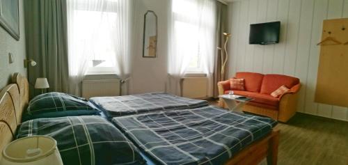 a bedroom with a bed and a couch and a chair at Gelder Dyck in Kevelaer
