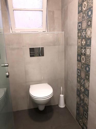 a white toilet sitting in a bathroom next to a window at Vistas de Lisboa Hostel in Lisbon