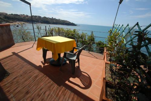 a yellow table and chairs on a deck with the ocean at Hotel Baia Del Sorriso in Castiglioncello