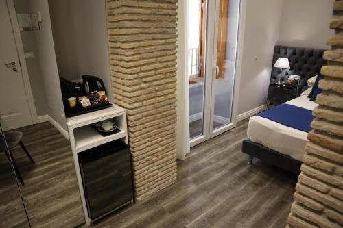 a hotel room with a brick wall next to a bed at MILLINA SUITES IN NAVONA in Rome