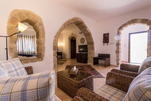 a living room with arches and a couch and a table at The Old Village Hotel & Resort in Wadi Musa