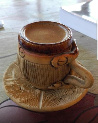 a cup of coffee sitting on a plate at Bob Marley Guest House in Aswan