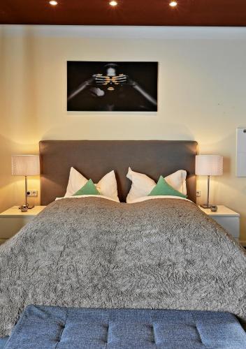 a bedroom with a large bed with two lamps at Design Apartment nähe Düsseldorf in Krefeld