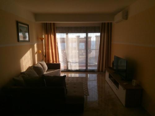 a living room with a couch and a television at Apartment Sea Space 2 in Dobra Voda