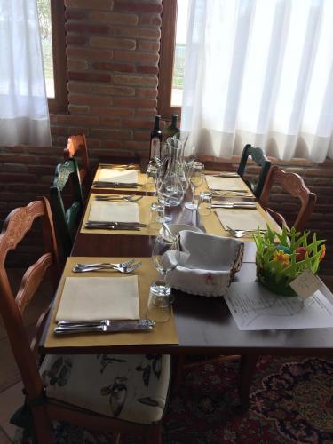 a wooden table with plates and wine glasses on it at Country House Salomè in Musile di Piave