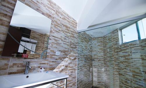 a bathroom with a sink and a glass shower at Apart Hotel Regina in Cochabamba