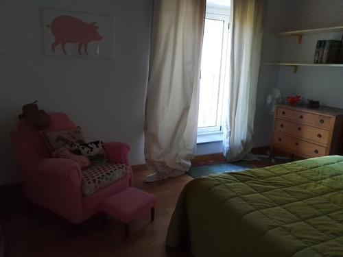 a bedroom with a bed and a chair and a window at B&B La Cascina Grossa in Alessandria