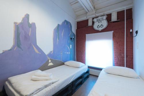 2 Betten in einem Zimmer mit Wandbild in der Unterkunft Keds. Hostel & Coffee house in Moskau