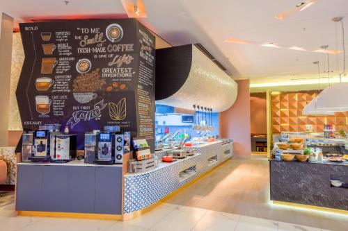 a coffee shop with a menu on the wall at Radisson Blu Gautrain Hotel, Sandton Johannesburg in Johannesburg