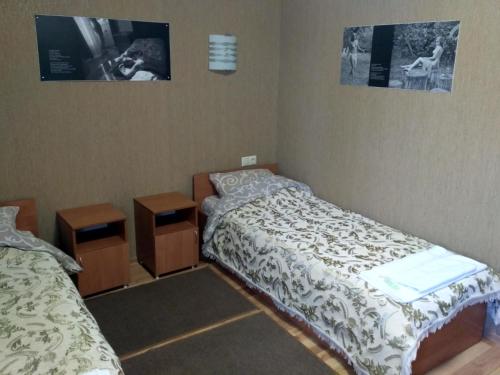 1 dormitorio con 2 camas y 2 mesitas de noche en Atlant Hotel, en Ostroh