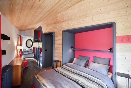 a bedroom with a large bed with a red headboard at Chalet Nantailly in Hauteluce