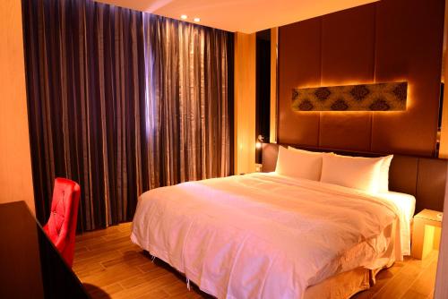 a bedroom with a large bed and a window at 雲林商旅 in Tuku
