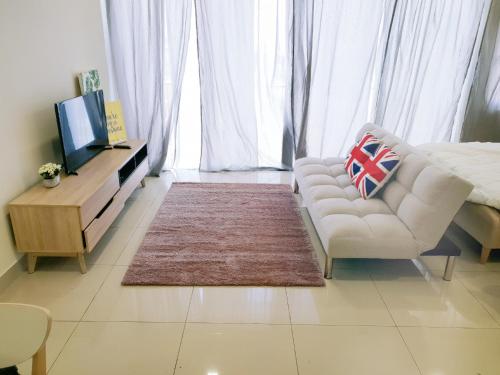 a living room with a white couch and a television at Trefoil Setia Alam- Simple No 5- Near Setia City Mall & Convention Centre in Setia Alam
