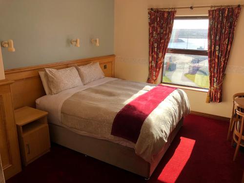 a bedroom with a large bed and a window at Pier House Bed & Breakfast in Inis Mor