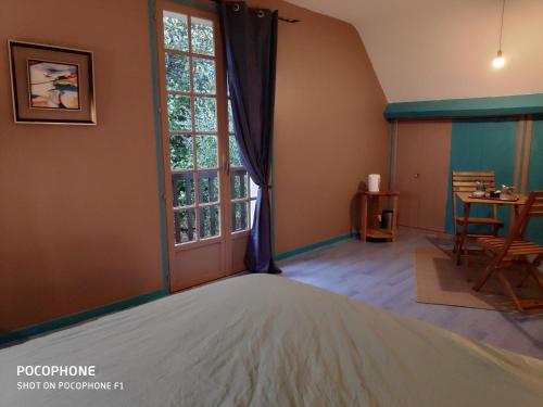 an attic bedroom with a bed and a window at B&B En plein coeur de la forêt in Artiguelouve
