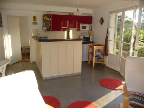uma cozinha com armários vermelhos e uma bancada em Splendide vue Pyrénées, Rez de jardin 2 chambres em Montjoie-en-Couserans