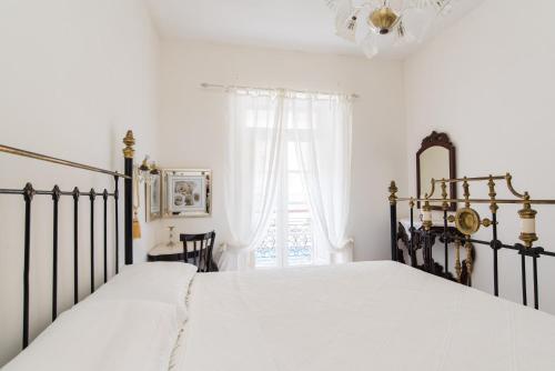 a bedroom with a bed with white sheets and a window at Merkanti Apartments in Valletta