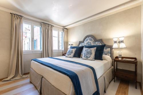 a bedroom with a large bed with blue pillows at Luxury Garden House La Baruffa- Dimora Italia Collection - in Venice