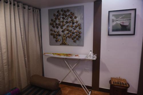 a room with a table and a tree on the wall at Square Suite in Mangalore