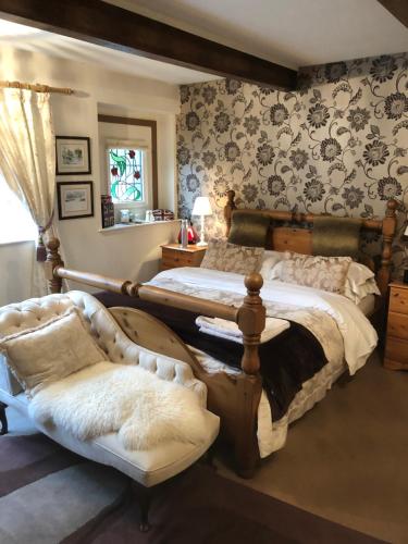 a bedroom with two beds and a couch at Over The Bridge Guest House in Ripponden